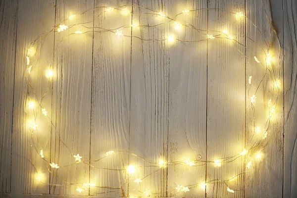 Hafif ahşap bir arka plan üzerinde Noel parlak çelenk