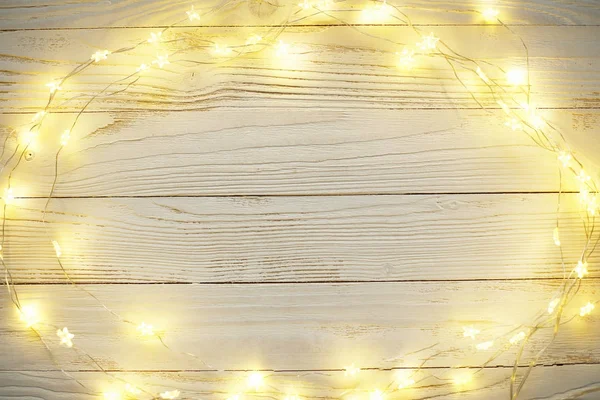 New Year background of bright garlands on a wooden