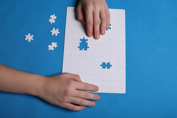 Witte details van een puzzel op een blauwe achtergrond. Een puzzel is een pu — Stockfoto