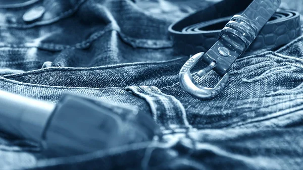 Denim clothes lying on the table with the glasses. Blue jeans wi — Stock Photo, Image