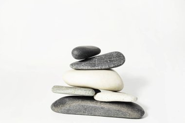 Beyaz arka planda siyah beyaz taşlar piramit