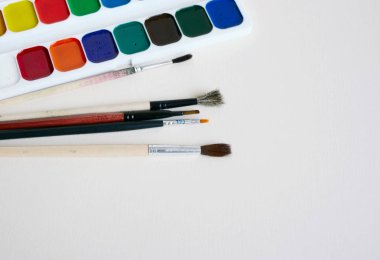 Boya fırçaları ve boyalar bir beyaz kağıt üzerinde bir dizi