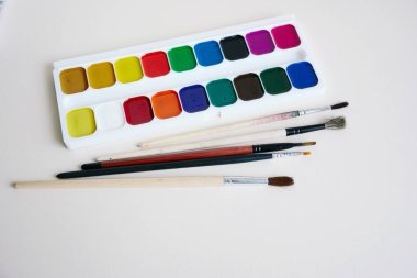 Boya fırçaları ve boyalar bir beyaz kağıt üzerinde bir dizi