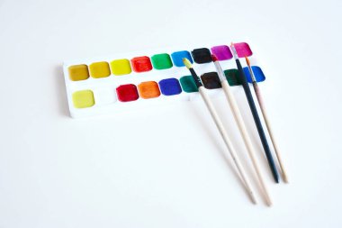 Boya fırçaları ve boyalar bir beyaz kağıt üzerinde bir dizi