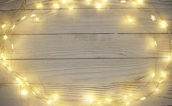 Ghirlande luminose di Natale su uno sfondo leggero di legno — Foto Stock