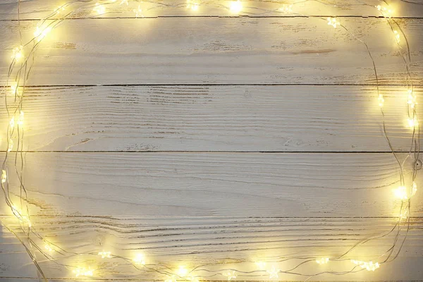 Christmas bright garlands on a wooden light background