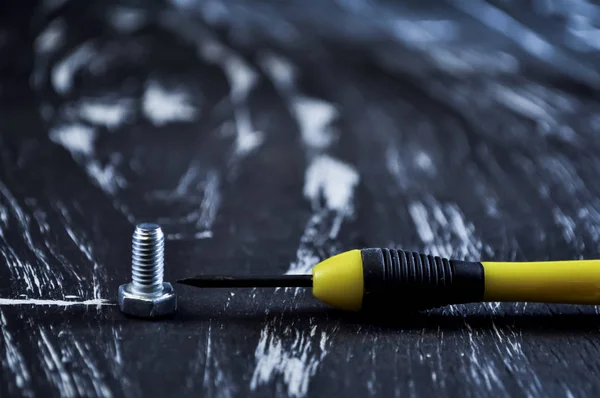 Nueces para reparaciones tumbadas en una mesa de madera. Tuercas y tornillos de hierro f —  Fotos de Stock