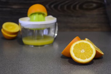 Tahta bir masanın üzerinde yatan portakal kesilmiş. Kahvaltıda meyve kesme. J