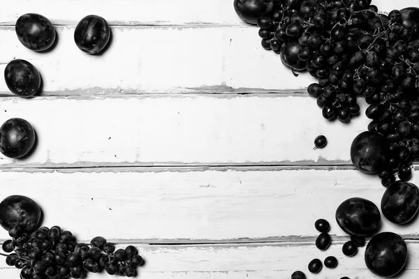 Чернослив и виноград на столе — стоковое фото
