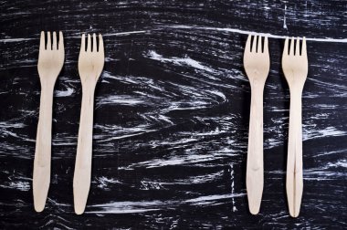 Gümüş çatal tahta bir masanın üzerinde yatan. Yemek için çatal bıçak takımı. Aygıt 