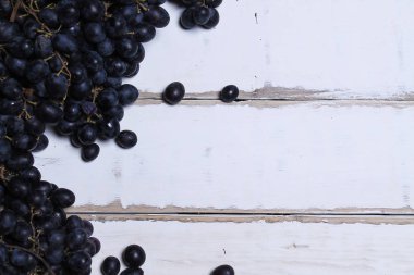 Tahta bir masanın üzerinde yatan üzüm