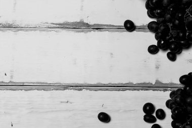 Tahta bir masanın üzerinde yatan üzüm