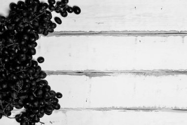 Tahta bir masanın üzerinde yatan üzüm