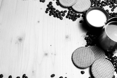 Kahve çekirdekleri ve süt ve kurabiye 