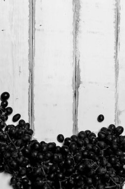 Tahta bir masanın üzerinde yatan üzüm