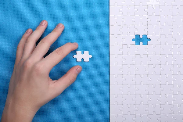 Szczegóły biały puzzle na niebieskim tle. Puzzle to pu — Zdjęcie stockowe