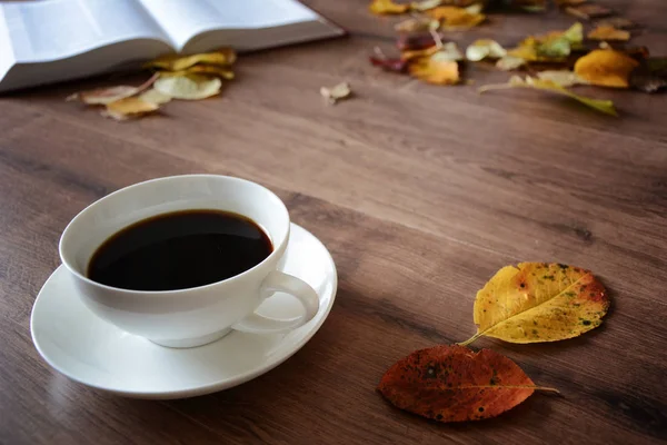 Oggetti su un tavolo di legno una tazza di caffè e un libro — Foto Stock