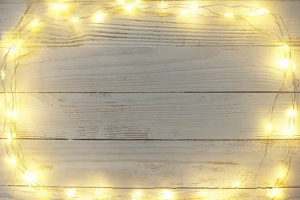 New Year background of bright garlands on a wooden — Stock Photo, Image