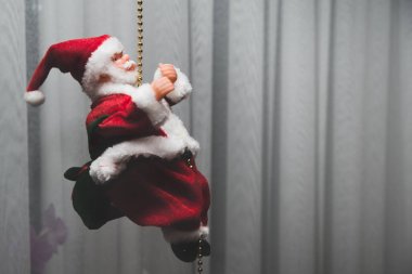 Noel Baba'nın görünümü. Oyuncak Noel Baba, kırmızı şapka, ellerini kaldırdı. Noel hediyeler, oyuncaklar vererek geliyor. Noel iklim kavramı. Mutluluk ve memnuniyet çocukların hediye alma.