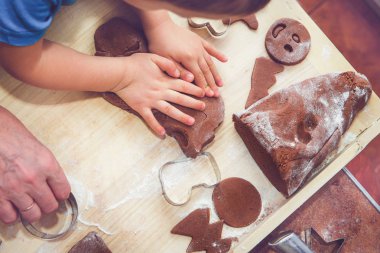 Fırın gingerbreads. Aile bir gingerbread hazırlanıyor. Çocuk hamur kneads. Birlikte yemek ve pişirme kavramı Noel, Aile, süre için hazırlanıyor. Masaya görücü usulü gingerbread ve kalıpları vardır.