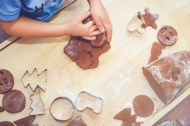 Fırın gingerbreads. Aile gingerbreads hazırlanıyor. Üstten Görünüm hamur yoğurma bir çocuğun. Pişirme ve pişirme birlikte Noel, Aile, süre için hazırlanıyor. Masaya görücü usulü gingerbread ve kalıpları vardır.