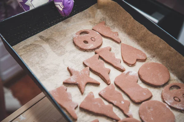 Gingerbreads全家人正在准备一个姜饼 Gingerbreads 在托盘上 准备圣诞节 时间为家庭 烹调一起和烘烤概念 在桌上被安排的姜饼和模子 — 图库照片