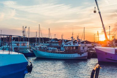 Yelkenli tekneler ve motorlu tekneler kısmen moored liman ve şaşırtıcı ve güzel günbatımı manzaralı dok. Çevre deniz ve balıkçı tekneleri parçaları. Cruise ve deniz seferleri.