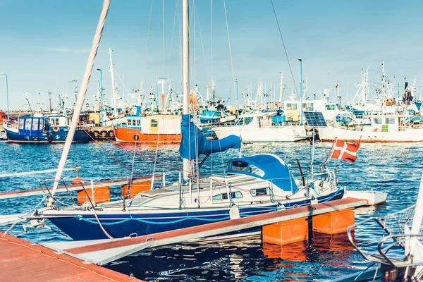 Sail Boats and motor boats moored in part of the harbor and dock with view on amazing and nice sunset. Near sea and parts of fishing boats. Cruise and sea expeditions.