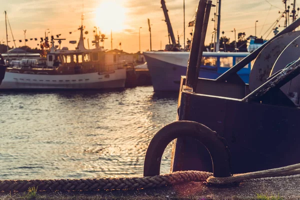 Sail Boats and motor boats moored in part of the harbor and dock with view on amazing and nice sunset. Near sea and parts of fishing boats. Cruise and sea expeditions.