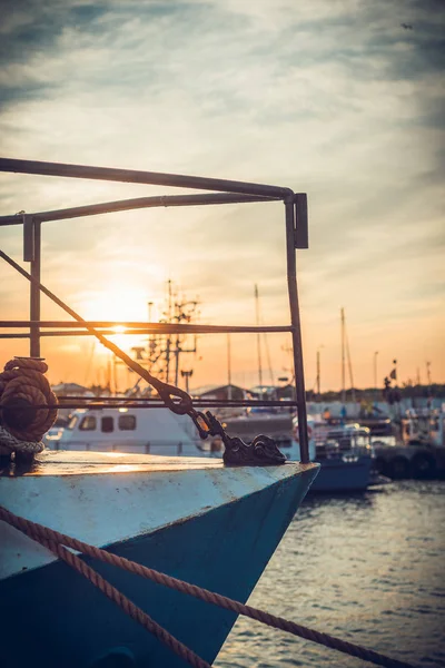 Sail Boats and motor boats moored in part of the harbor and dock with view on amazing and nice sunset. Near sea and parts of fishing boats. Cruise and sea expeditions.