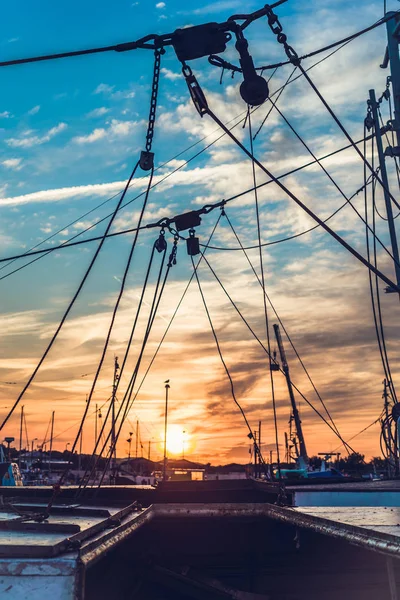 Sail Boats and motor boats moored in part of the harbor and dock with view on amazing and nice sunset. Near sea and parts of fishing boats. Cruise and sea expeditions.