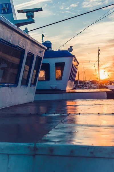 Sail Boats and motor boats moored in part of the harbor and dock with view on amazing and nice sunset. Near sea and parts of fishing boats. Cruise and sea expeditions.