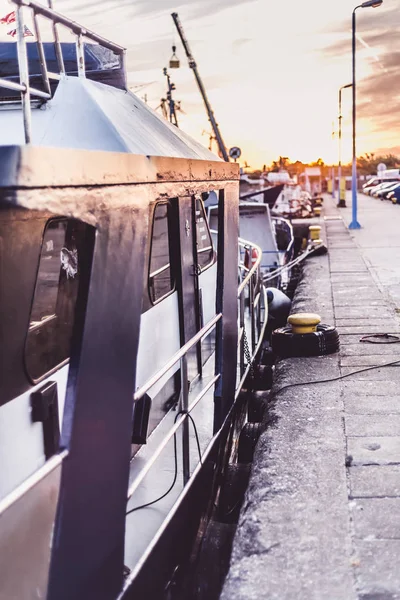 Sail Boats and motor boats moored in part of the harbor and dock with view on amazing and nice sunset. Near sea and parts of fishing boats. Cruise and sea expeditions.