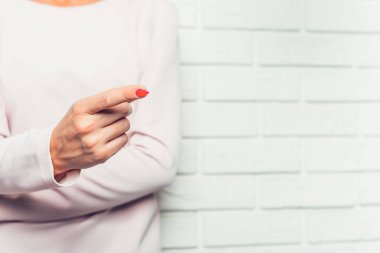 Bir şey bir kadın işaret parmağım. Pembe pastel elbiseli bir kadın kolları birbirlerine onun parmak tarafına işaret katlanmış var. Puanlama.