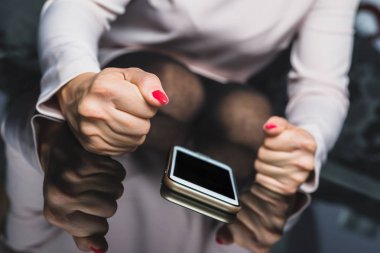 Telefonda yumruk at. Öfke el telefon telefon vurur. Kadınsı el elini masanın üzerinde yatan cep telefonuyla vurmak istiyor. Kötü mesaj, değil yanıt iletileri, kötü iletileri için.