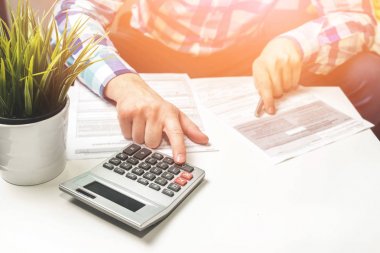 Zenginleştirme ve finansal büyüme kavramı. Para tasarrufu. Adam çalışıyor hesaplanıyor. Gelir vergisi zammı. Yazılı gol bir kağıt üzerinde işaret eden kişi işyerinde iş planı yazıyor. Hesap makinesi.