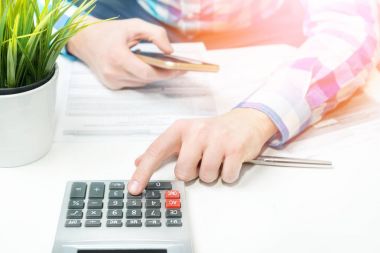 Zenginleştirme ve finansal büyüme kavramı. Para tasarrufu. Adam çalışıyor hesaplanıyor. Gelir vergisi zammı. Yazılı gol bir kağıt üzerinde işaret eden kişi işyerinde iş planı yazıyor. Hesap makinesi.