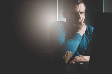 Adam merak ediyor, laptop önünde oturma belirler. İlginç bir şey, dehşet bulma. Adam bir harekete düşünce eliyle çenesini destekler.