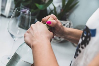 Kadın bir şişe şarapla, açmaya çalışıyor alkol. Alkol, şarap için için özlem. Alkol sorunları kavramı. İçme şarap, parti, eğlence, yalnızlık, özlem.