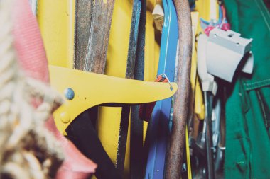 A set of tools on a yellow wall. Concept of work in a home workshop, doing homework. Tools such as the grinding wheel, saw hang on the wall.