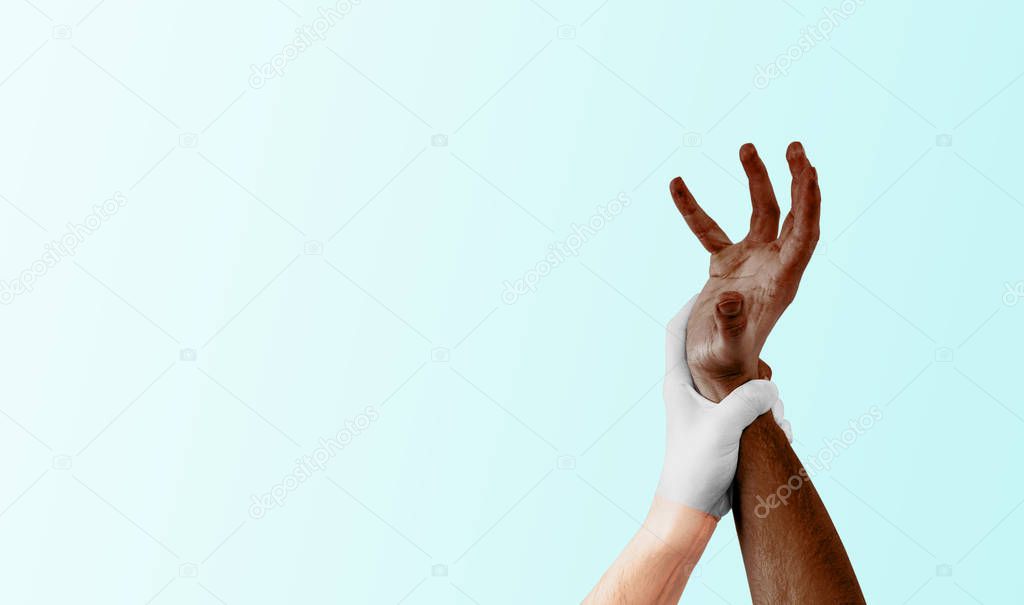 A hand in a white glove grasps a dark hand on a light background. The concept of anti-racism, lack of tolerance towards other people. Equality and equality for all people. Calling for help.