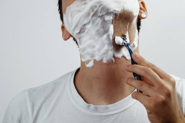 Bir erkek tıraş. Adam bir jilet ve tıraş köpüğü kullanarak çıkmıyor. Adam kendini çıkışa hazırlanıyor önemser. Sakalları, büyütme, bıyıklar kurtuluyorum. Kişisel hijyen.