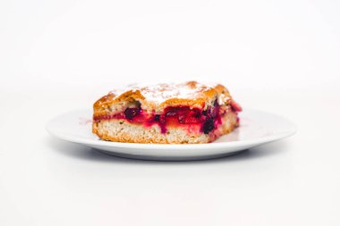 Lezzetli ve taze ravent keki. Beyaz bir arka planda beyaz bir tabakta kırmızı meyveli bir pasta. Tabakta ikram. Tatlı ekşi hamur.