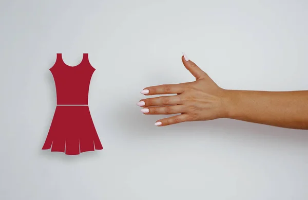 ピンクのヒントを持つ女性の手のトップビューは 赤いドレス 服のために達する 購入の概念 価格の削減 灰色の明るい背景に女性の手 ショッピング — ストック写真