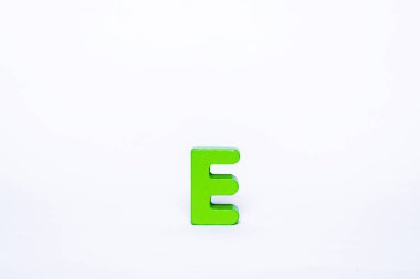 Beyaz arka planda tek bir yeşil E harfi. İzole edilmiş ahşap alfabe harfi.