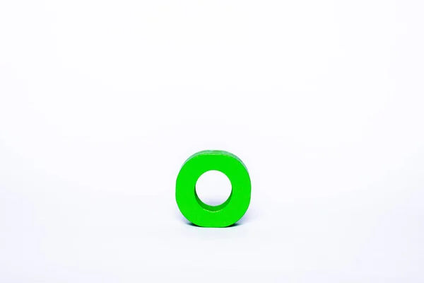 白色背景上的一个绿色字母O 孤立的木制字母 — 图库照片