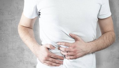 Karın ağrısı var. Adam midesini tutuyor ve midesinde sorun var. Tıbbi ve ilaç konsepti. Hazımsızlık, gıda zehirlenmesi.