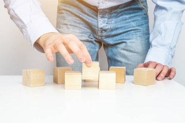 İçerik olmadan tahta bloklar yığmak. İş konsepti, içerik takviyesi. Bir adam birbiri ardına boş tahta bloklar yerleştirir ve bir konsept yaratır..