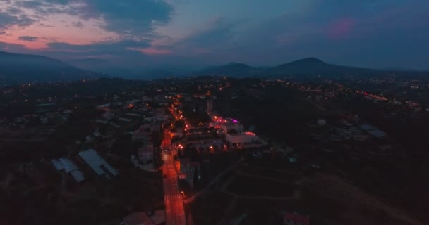 Ciudad en el fondo de las montañas y la puesta de sol — Vídeos de Stock