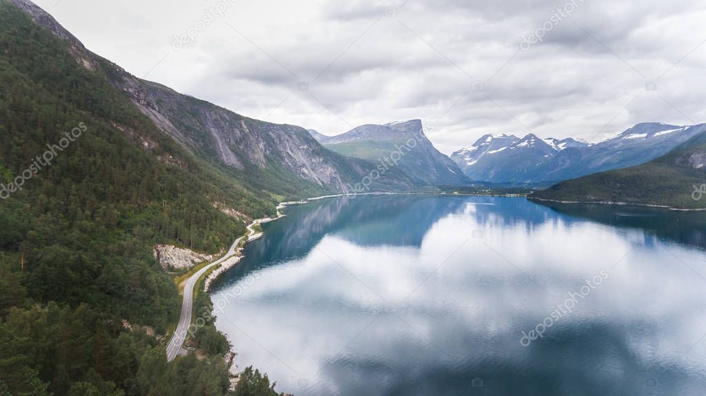 Aerial scenic mountain view of a beautiful Norwegian fjord along the street.